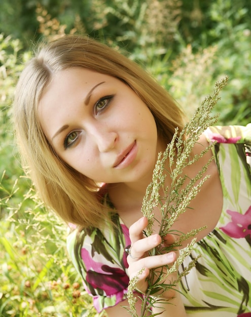 Junge Frau, die im Gras sich entspannt