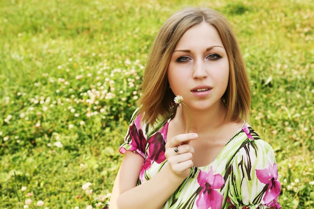 Junge Frau, die im Gras sich entspannt