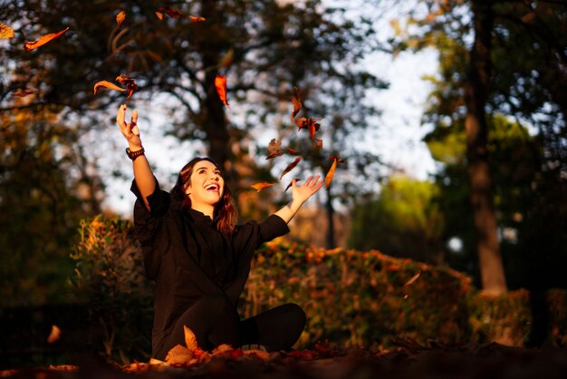 Junge Frau, die im Herbstpark entspannt