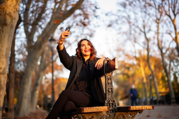 Junge Frau, die im Herbstpark entspannt