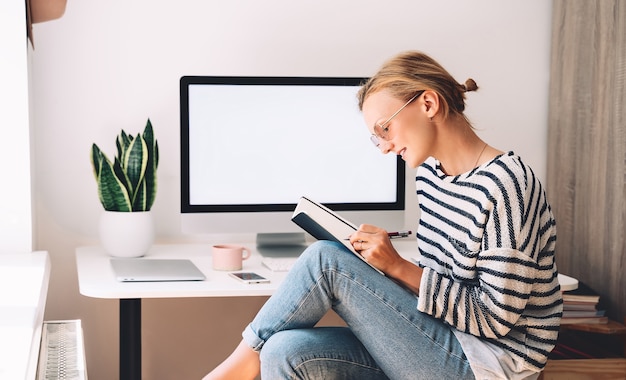 Junge Frau, die im Homeoffice arbeitet Mädchen mit Brille arbeitet mit neuem Startup-Projekt