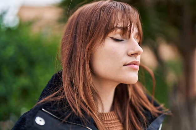 Junge Frau, die im Park atmet