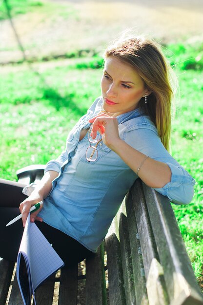 Junge Frau, die im Park studiert