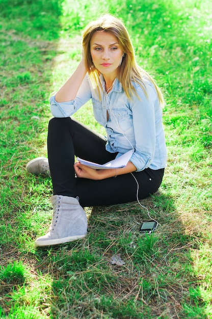 Junge Frau, die im Park studiert