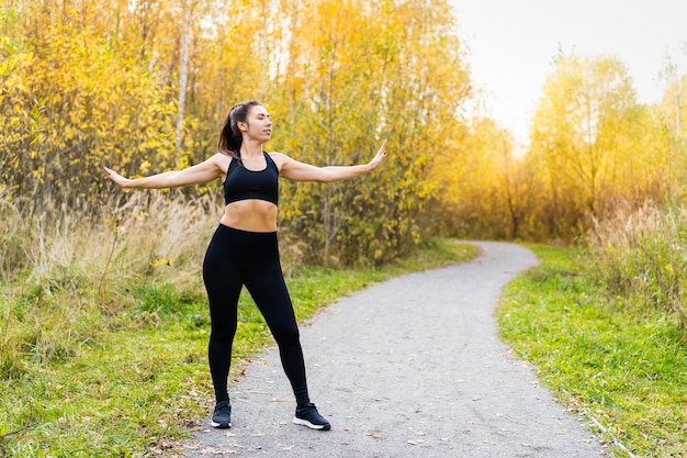 Junge Frau, die im Park während des Herbstes läuft