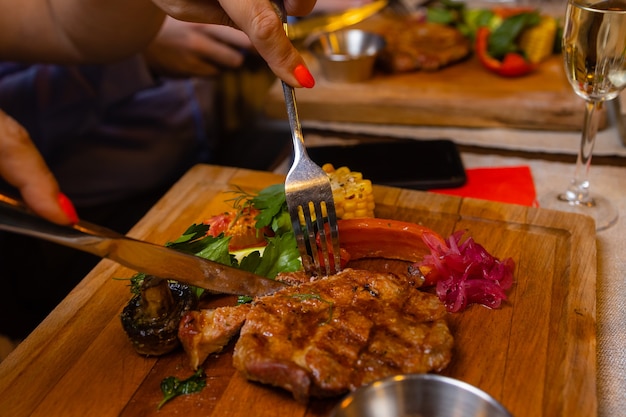 Junge Frau, die im Restaurant gegrilltes Steak isst?