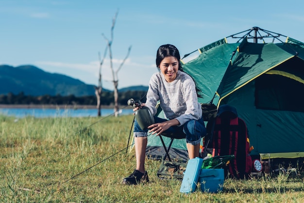 Junge Frau, die im Sommer im Wald campt