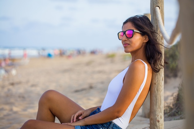 Junge Frau, die im Strand sitzt