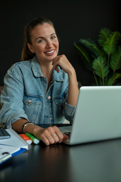 Junge Frau, die im trendigen Café am Laptop arbeitet.