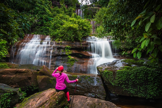 Foto junge frau, die im wasserfall wandert