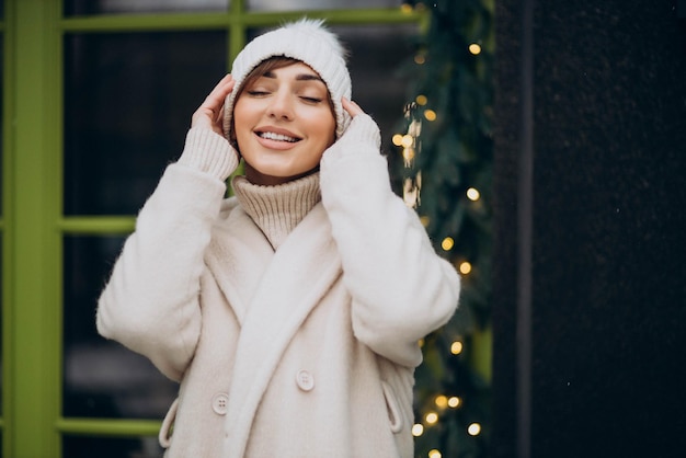 Junge Frau, die im Winter am Café steht