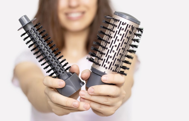 junge frau, die in der hand eine moderne rotative haarbürste kopfart hairsmiling girlclose uphair hält