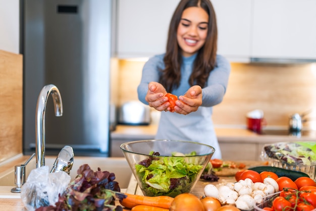 Junge Frau, die in der Küche kocht. Gesundes Essen - Gemüsesalat. Diät. Diät Konzept.