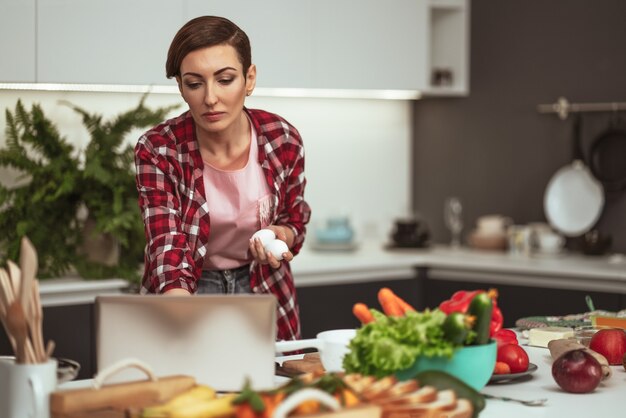 Junge Frau, die in der Küche kocht