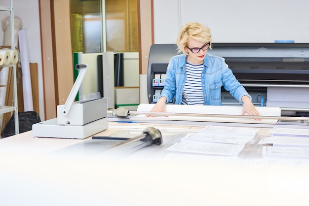 Junge Frau, die in Druckerei arbeitet