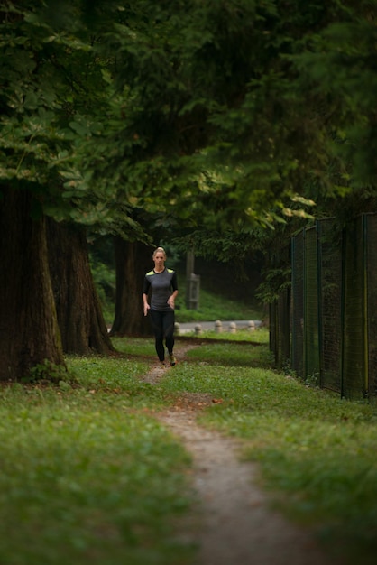 Junge Frau, die in einem bewaldeten Waldgebiet läuft - Training und Training für Trailrun-Marathon-Ausdauer - Fitness-Konzept für einen gesunden Lebensstil