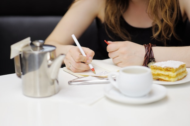 Junge Frau, die in einem Café, Abschluss herauf Foto arbeitet