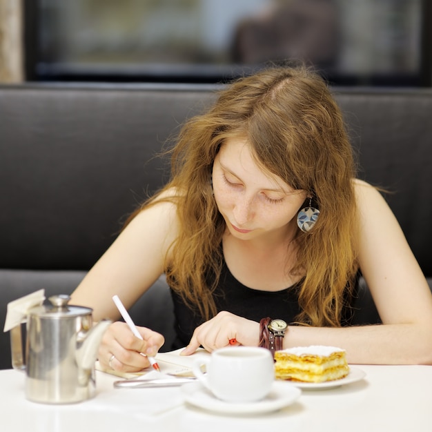 Junge Frau, die in einem Café arbeitet oder studiert