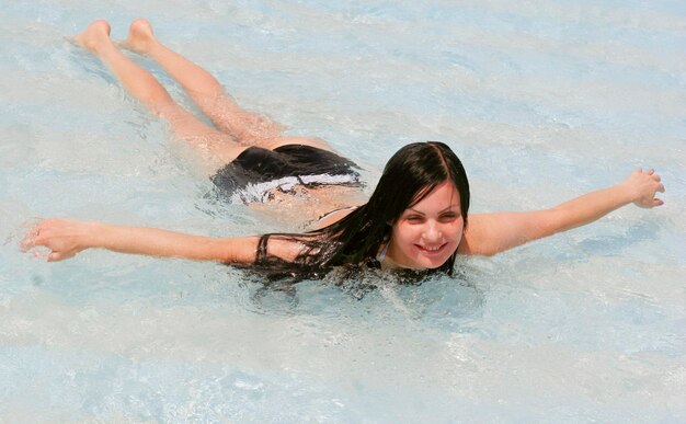 Junge Frau, die in einem Schwimmbad lächelt