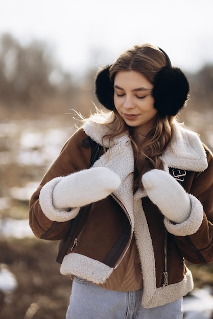 Junge Frau, die in einen Winterpark geht