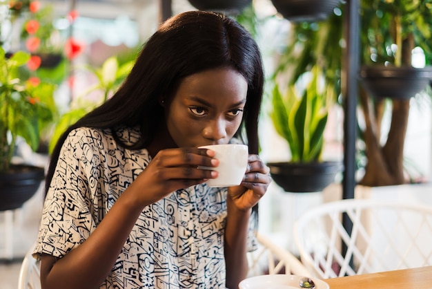 Junge Frau, die Kaffee im modernen Café trinkt