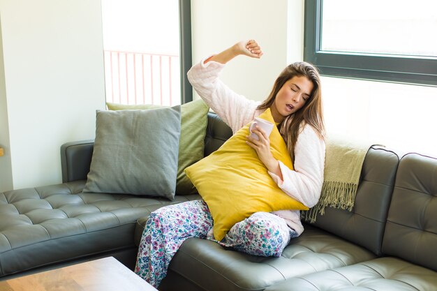 Junge Frau, die Kaffee zu Hause trinkt