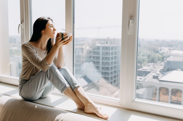 Junge Frau, die Kaffee zu Hause trinkt