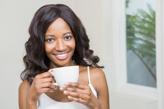 Junge Frau, die Kaffeetasse hält