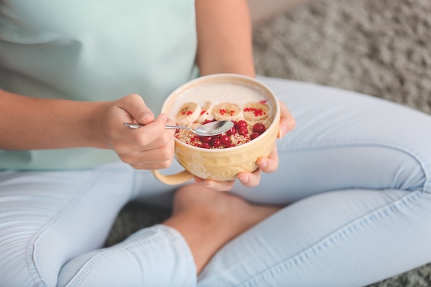 Junge Frau, die leckeren Joghurt zu Hause, Nahaufnahme isst