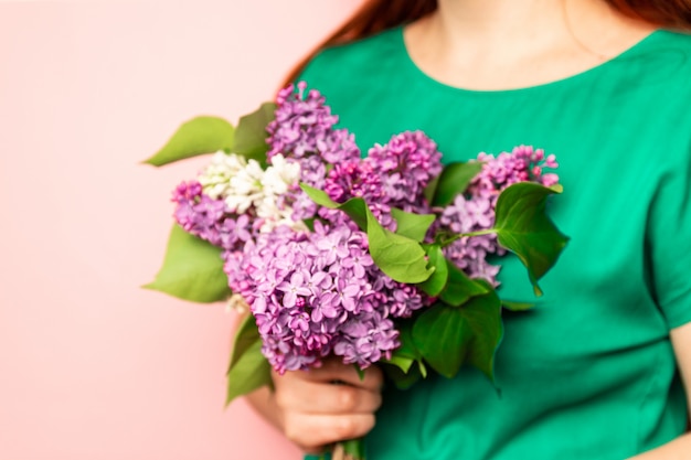 Junge Frau, die lila Blumen hält