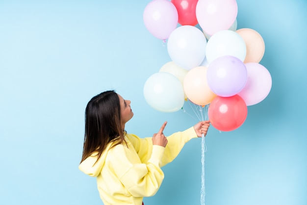 junge Frau, die Luftballons über isoliert hält