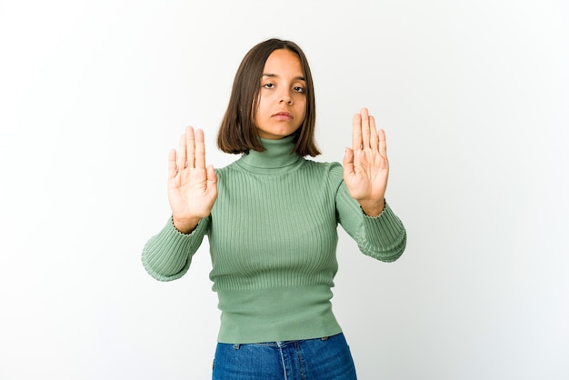 Junge Frau, die mit ausgestreckter Hand steht, die Stoppschild zeigt