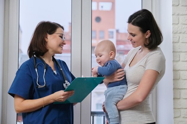 Junge Frau, die mit dem Arzt über ihr Baby spricht