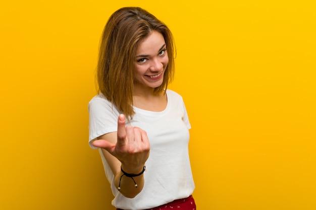 Junge Frau, die mit dem Finger auf Sie zeigt, als ob Einladung näher kommen