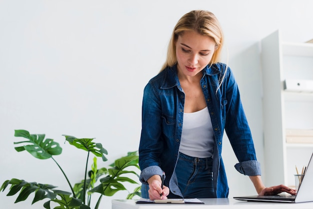 Foto junge frau, die mit dokumenten im büro arbeitet