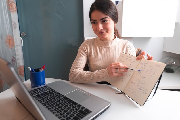 Junge Frau, die mit einem Laptop arbeitet