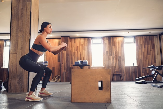 Junge Frau, die mit einer Box im Fitnessstudio arbeitet