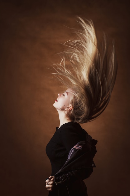 Junge Frau, die mit ihren langen Haaren aufwirft