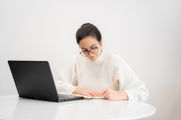 Junge Frau, die mit Laptop schreibt und arbeitet