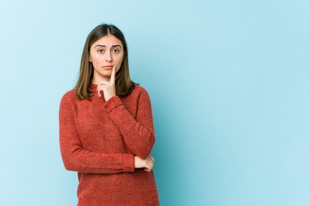 Junge Frau, die mit zweifelhaftem und skeptischem Ausdruck seitwärts schaut