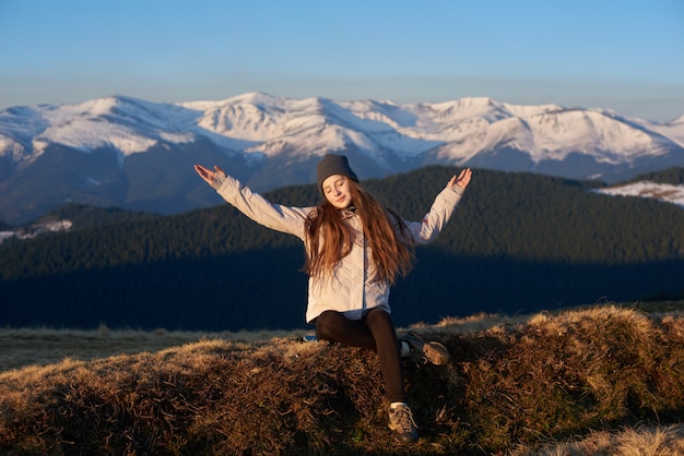 Junge Frau, die Morgensonne in den Bergen genießt