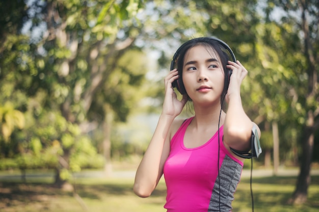 junge Frau, die Musik im Park hört