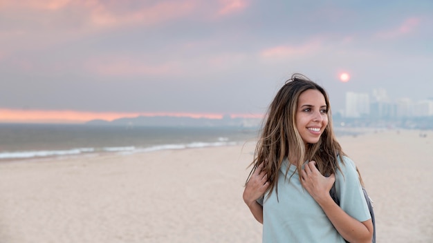 Junge Frau, die ohne Covid am Meer reist