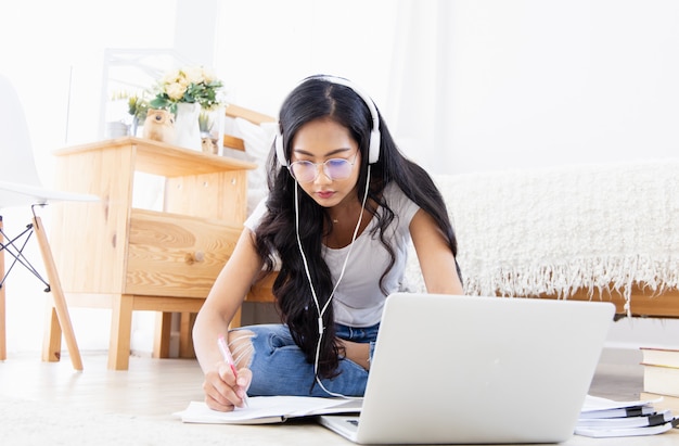 Junge Frau, die online von zu Hause aus arbeitet