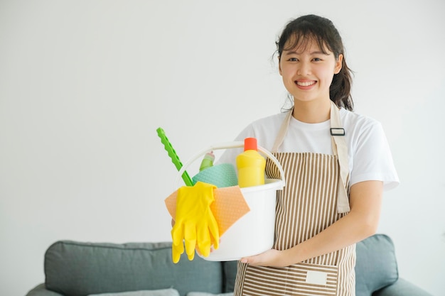 Junge Frau, die Reinigungsgeräte zur Reinigung bereithält