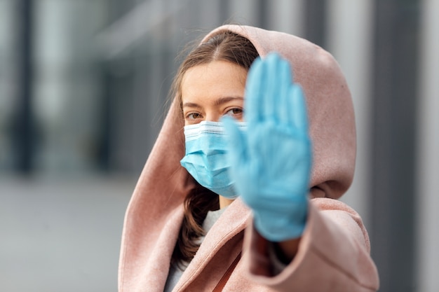 Junge Frau, die Schutzgesichtsmaske im Freien trägt