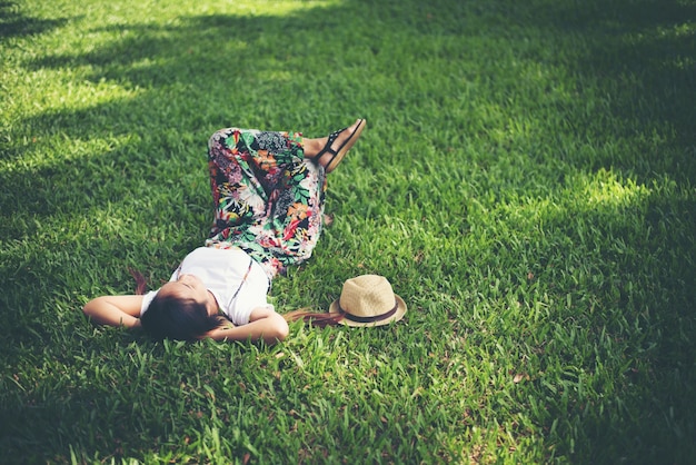 Junge Frau, die sich auf Gras hinlegt. Entspannungszeit.