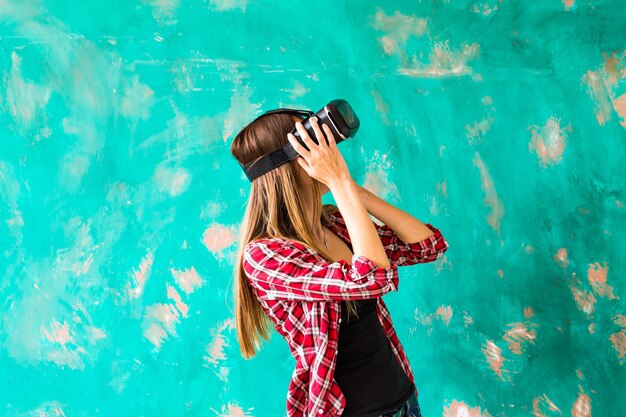 Junge Frau, die sich für die Verwendung des Virtual-Reality-Geräts schockiert.