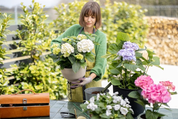 Junge Frau, die sich um Blumen im Garten kümmert