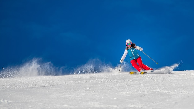 Junge Frau, die Ski auf dem Berg übt